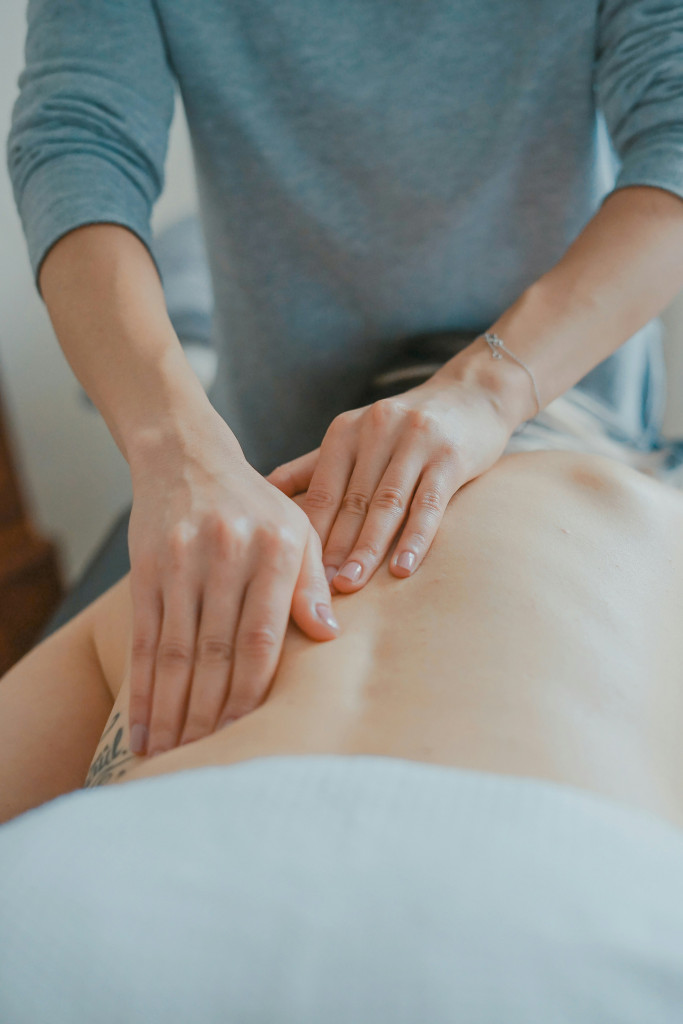 hands giving back massage in clinical setting