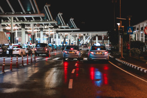 lanes of cars waiting to cross through a border inspection at night
