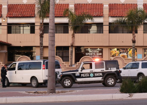 police officer in Mexico's Policia Municipal giving ticket to white van driver in front of a large building